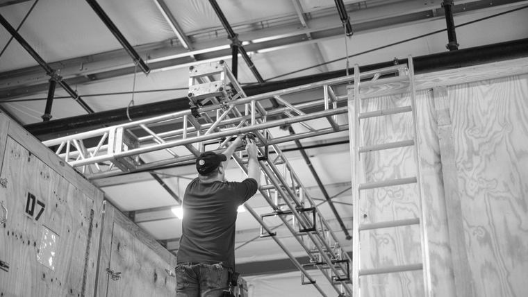 Cable being run overhead through the open ceiling of a commercial space