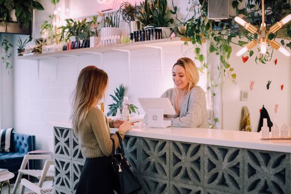 A customer at the counter of a small retail shop