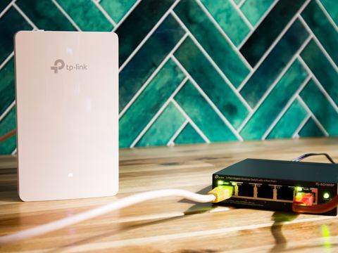 A home WiFi router and network switch set up on a table